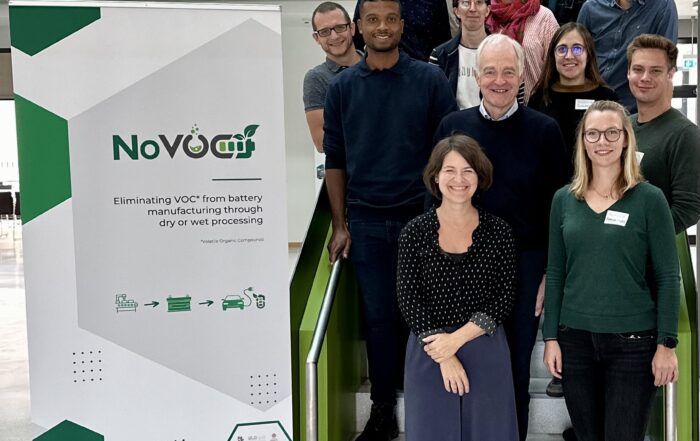 The NoVOC team members on a staircase next to the rollup