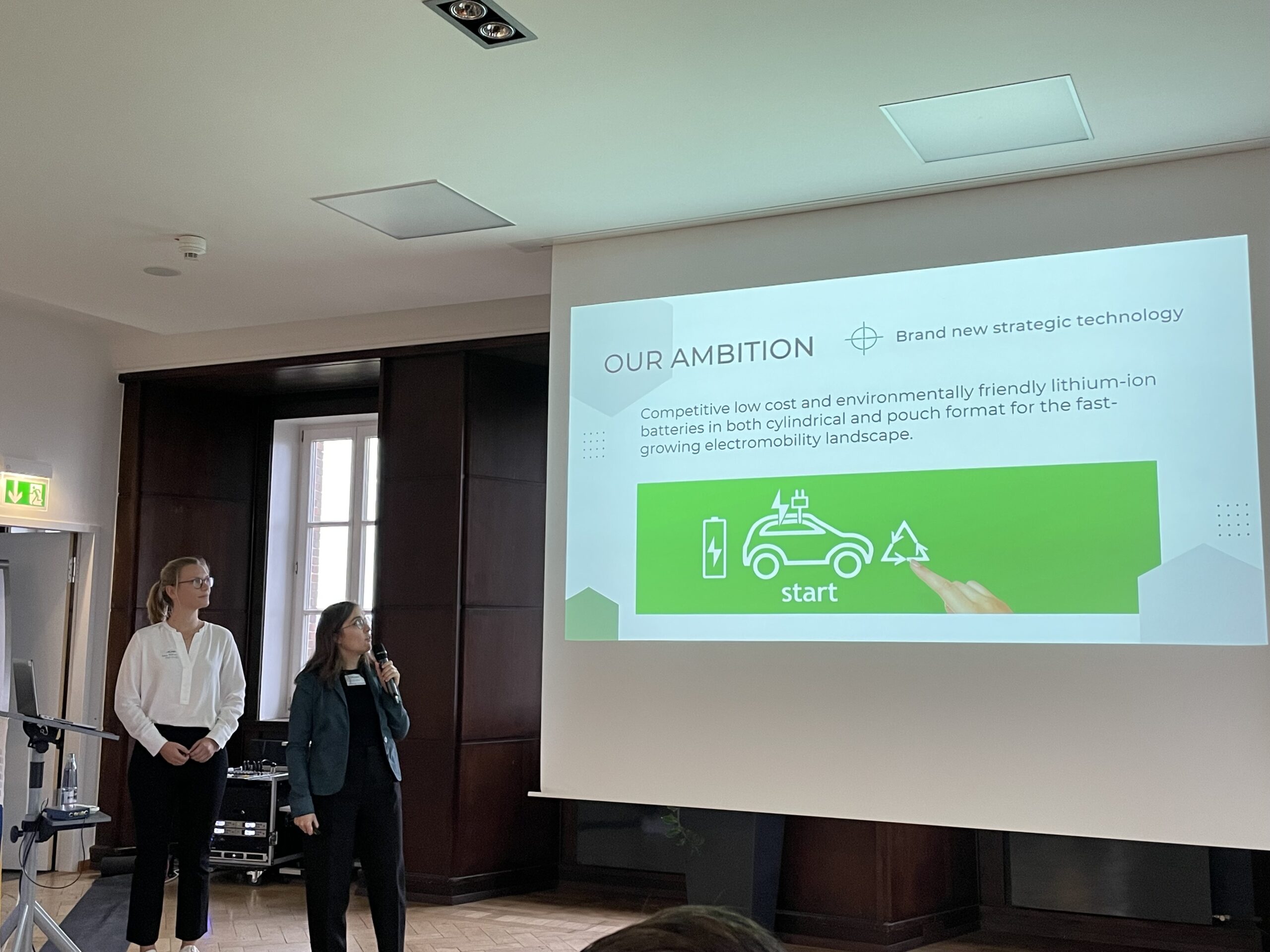 Guiomar Hernandez and Svenja Schreiber in front of a screen giving a talk