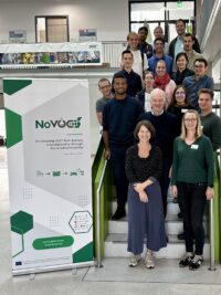 The NoVOC team members on a staircase next to the rollup