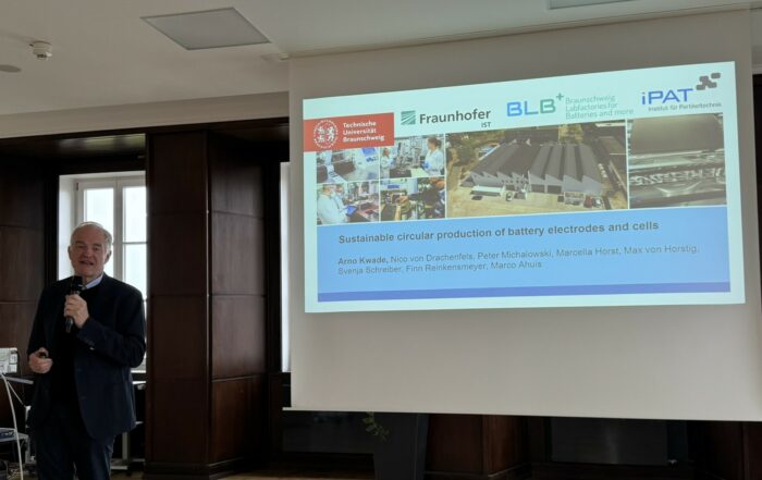 Prof Arno Kwade in front of a screen giving a talk